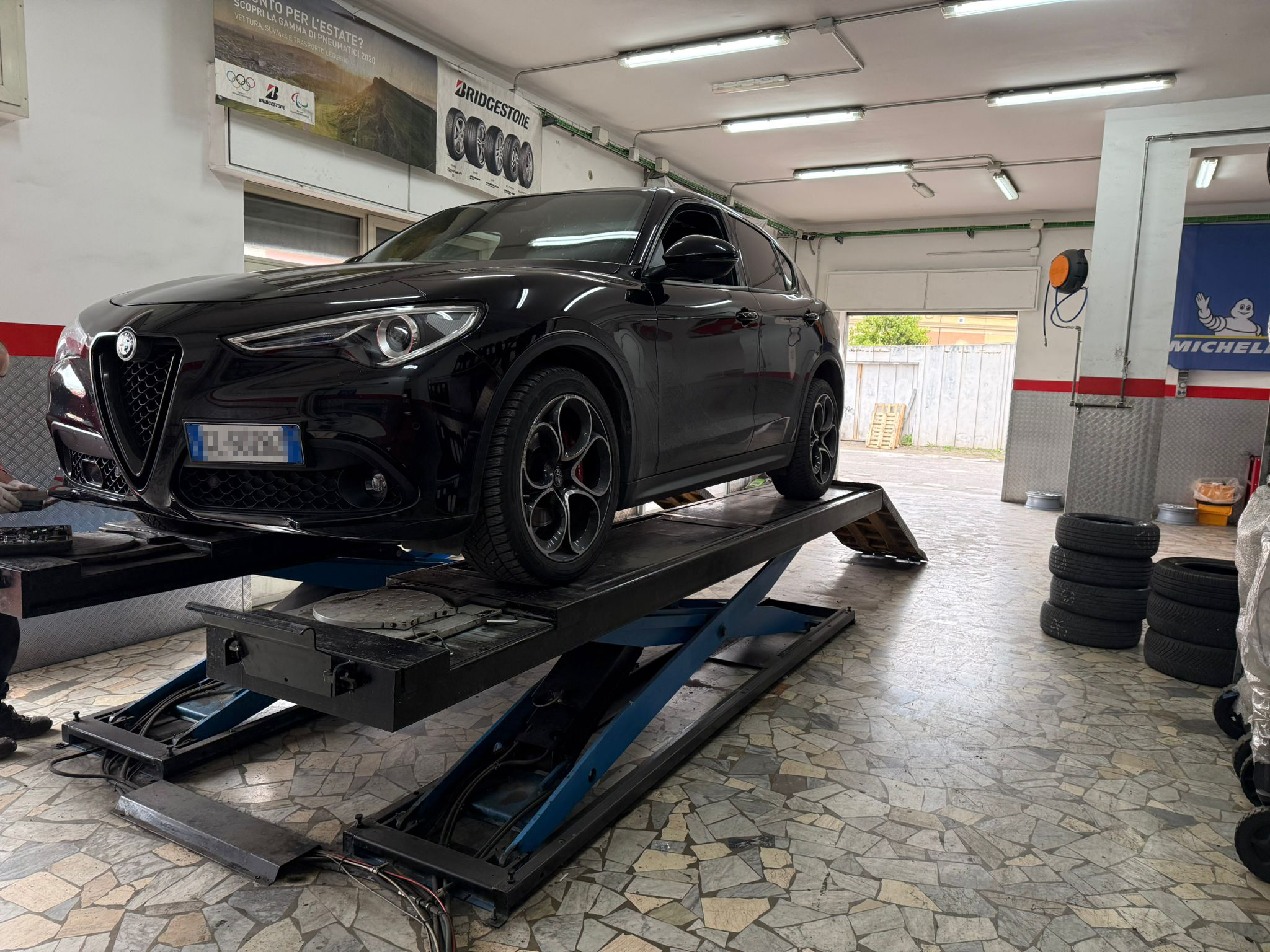 SUV nero in lavorazione sul ponte sollevatore