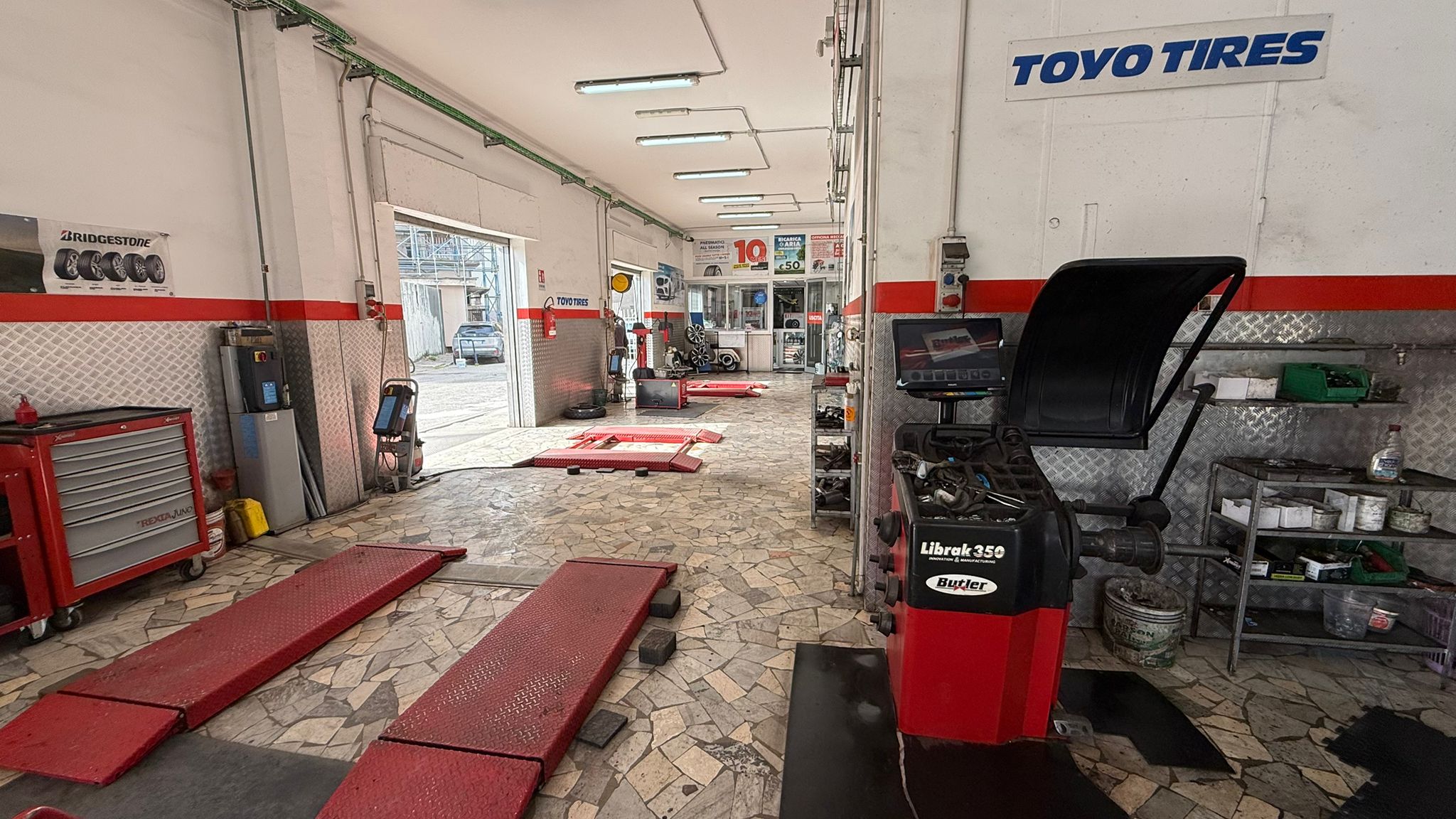 SUV in officina vicino alla zona di montaggio e lavorazione pneumatici