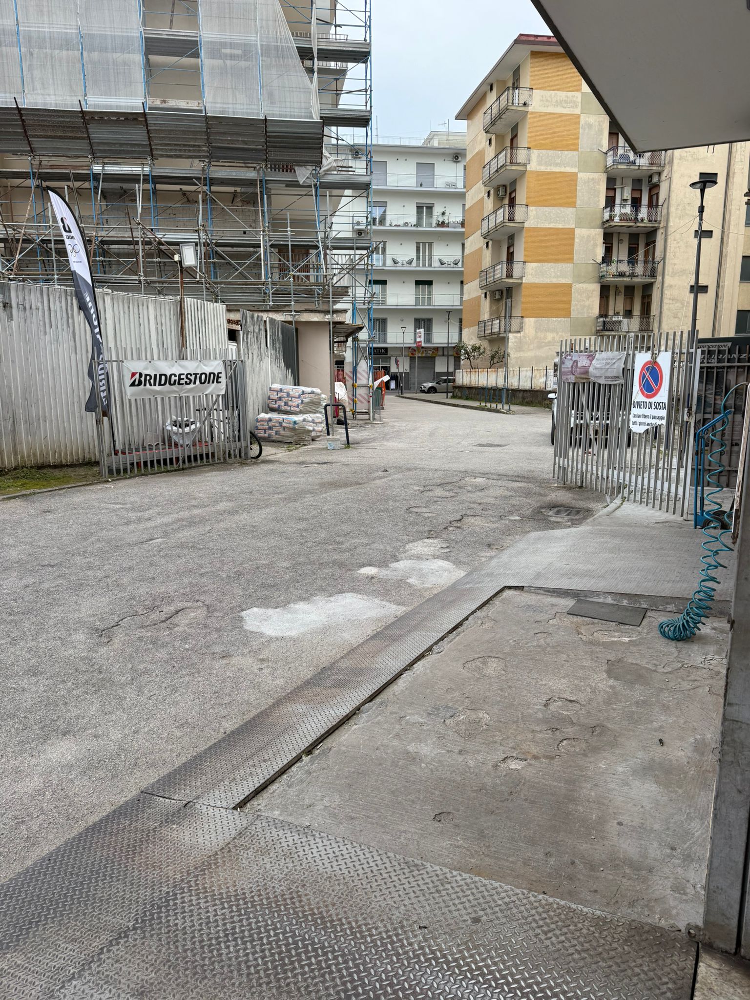 Officina vista dalla strada con insegna e contesto circostante