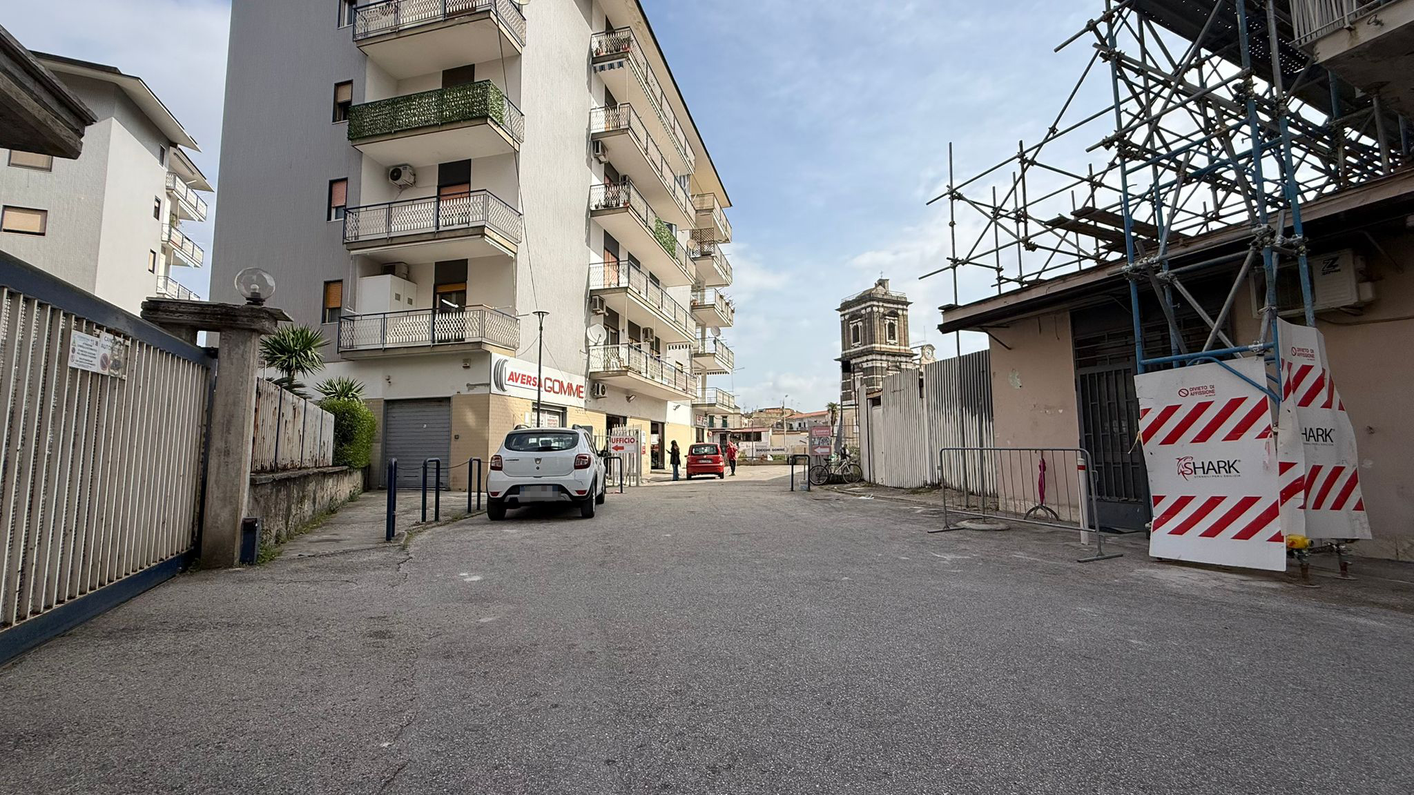 Vista dalla strada verso Aversa Gomme con contesto urbano e accesso al punto vendita
